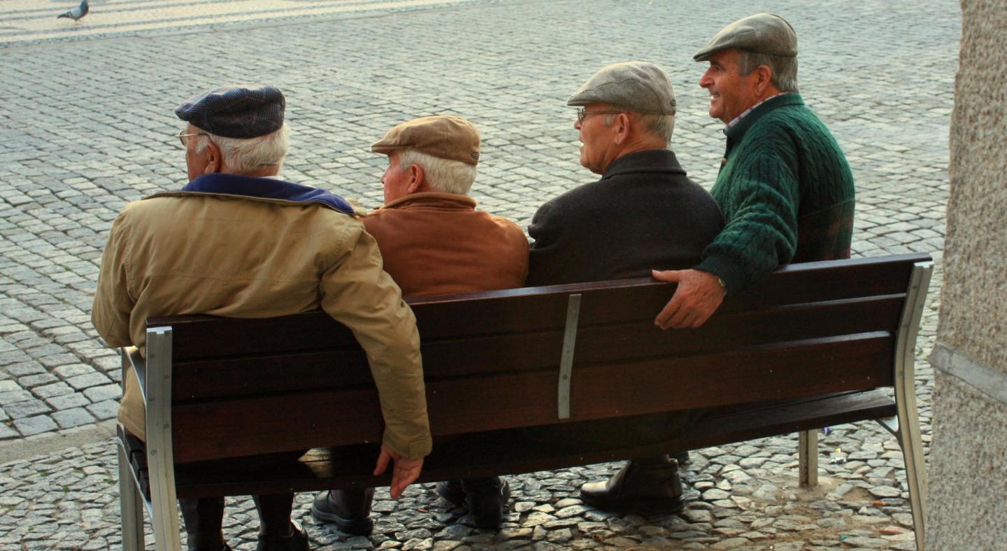 Four elderly men sitting on a bench