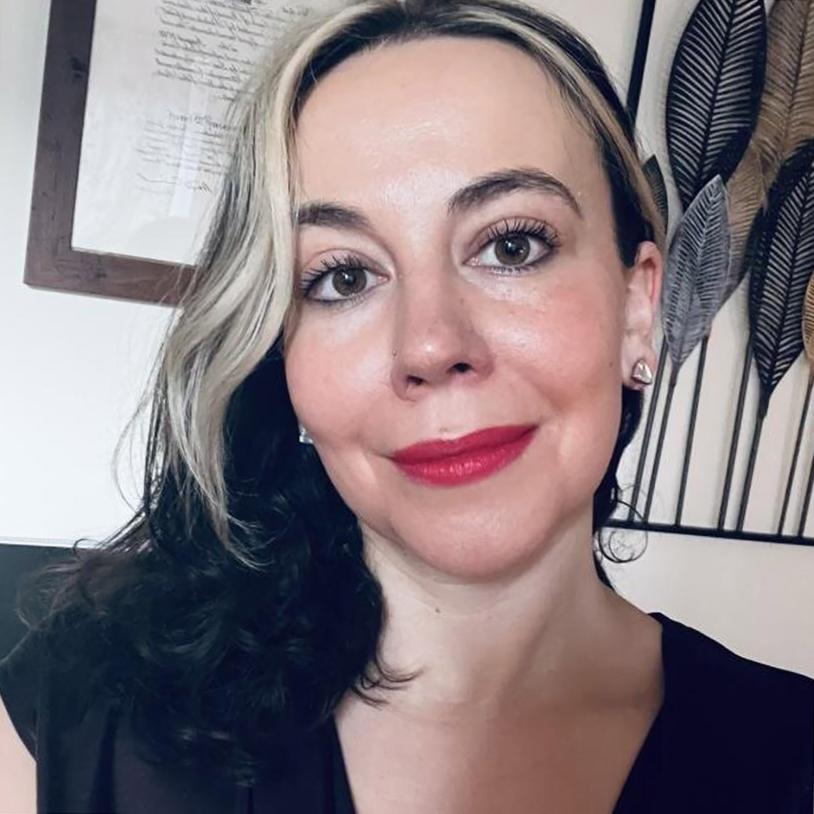 A woman with red lipstick and a blond streak in her hair.