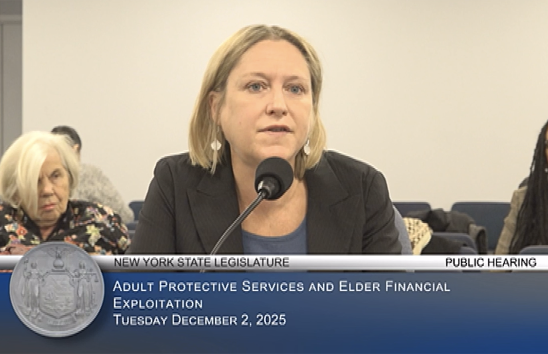 White woman with blonde bob speaking into a mic. 