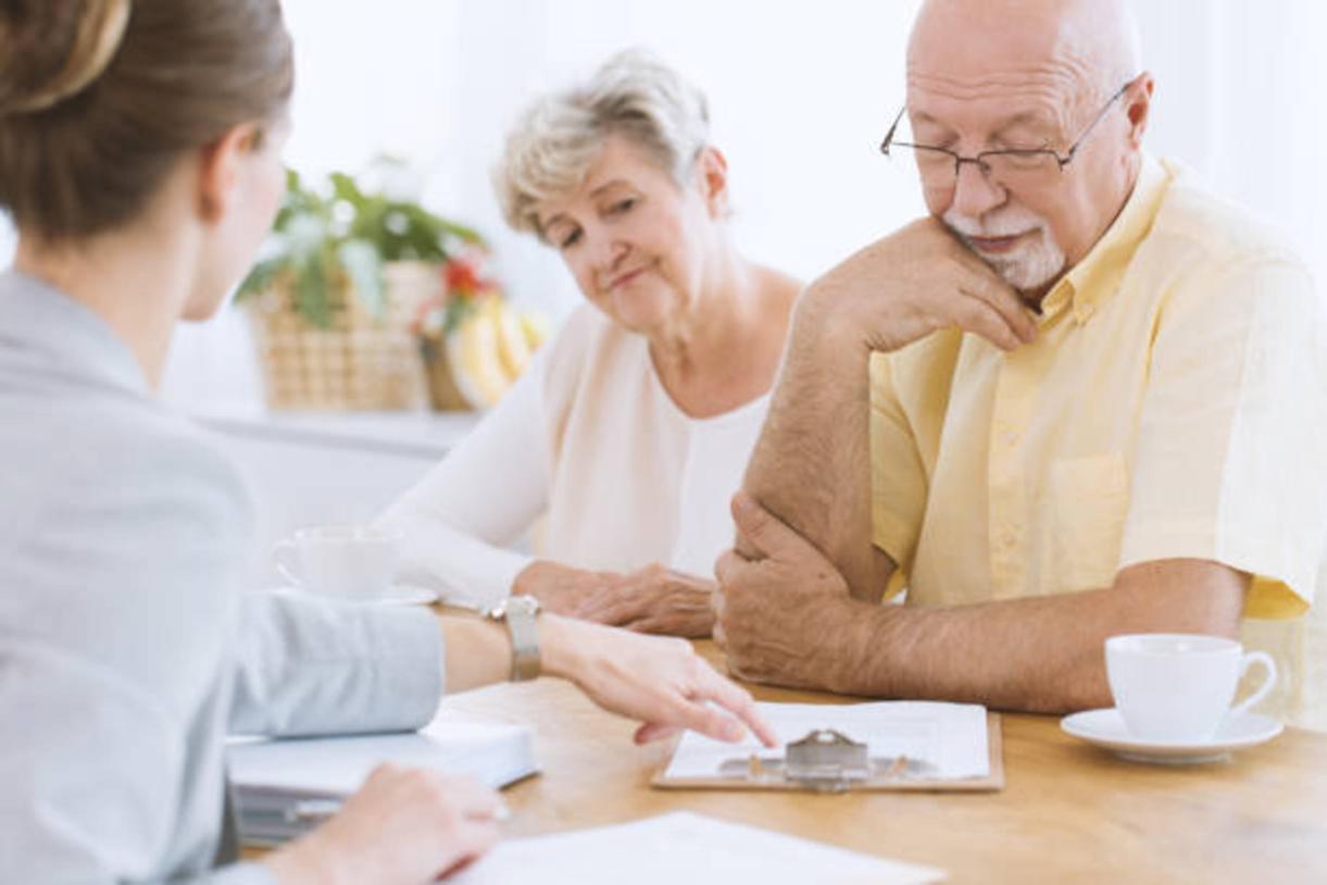 older couple looking at paperwork with younger woman