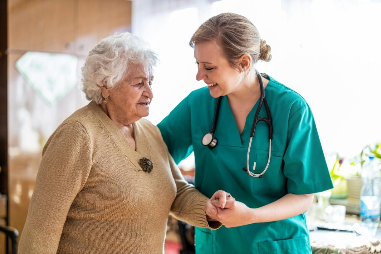 young doctor helping older woman