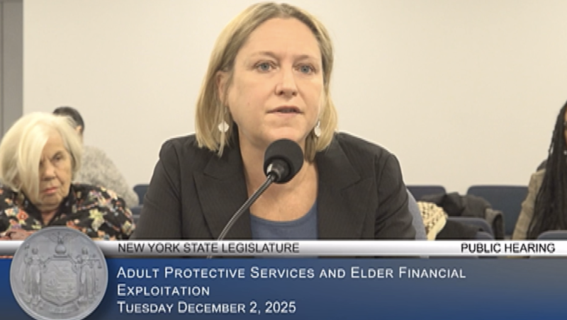 White woman with blonde bob speaking into a mic. 