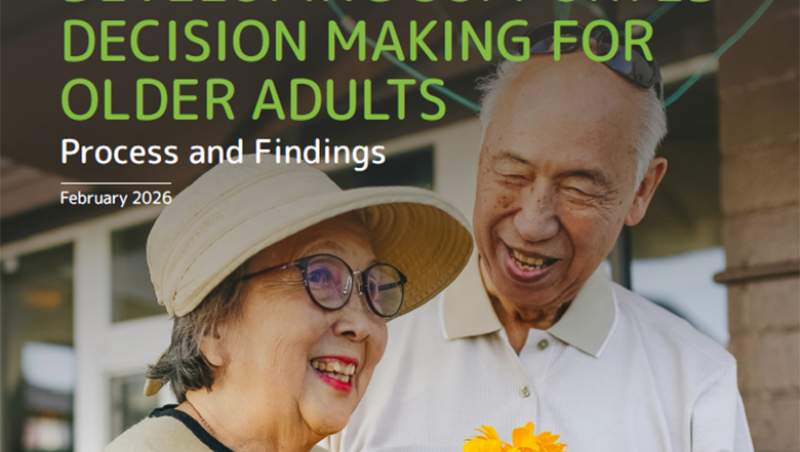 An older Asian couple smiling with a bouquet of flowers.