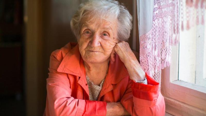 older woman at table looking into camera