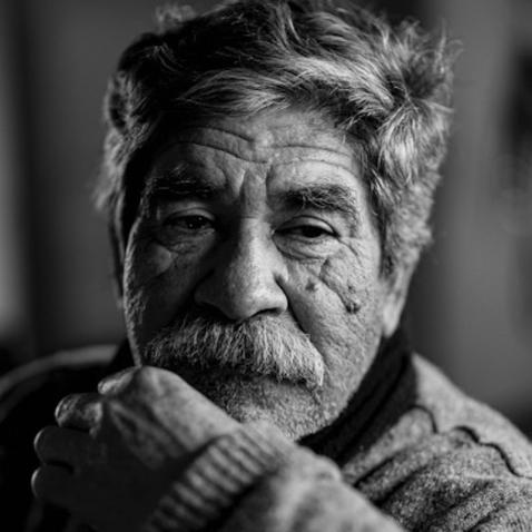 Black and White headshot of an older man with wrinkles and a mustache