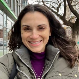 A woman with dark brown hair smiling.