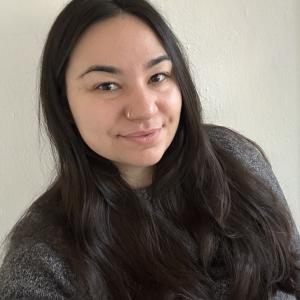 A woman with a nose ring and long dark hair.